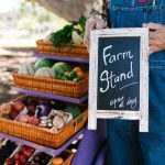 Banca ao ar livre com frutas e verduras frescas organizadas em cestos.