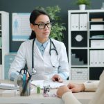 Médico conversa com paciente em uma clínica moderna sobre opções de tratamento.