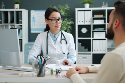 Médico conversa com paciente em uma clínica moderna sobre opções de tratamento.